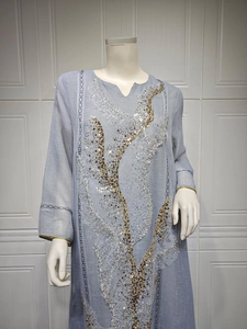 Detailed view of the intricate gold and silver sequin embroidery on the light blue tunic
