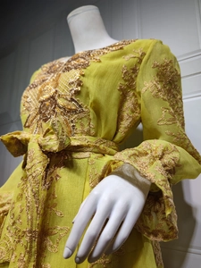 Detailed view of intricate gold floral embroidery and sequins on lime green chiffon dress