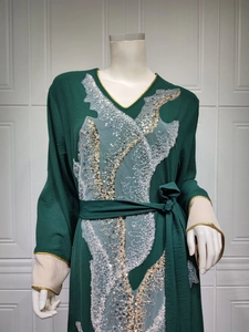 Détail de l'abaya vert foncé avec col en V doré et broderies de dentelle à paillettes