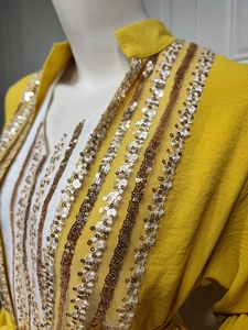 Detailed embroidery with gold and bronze sequins on a yellow puff sleeve dress