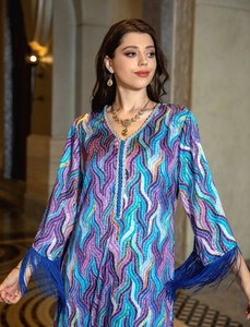 Macro detail of ethnic kaftan dress with wavy prints, v-neckline and sleeve fringe