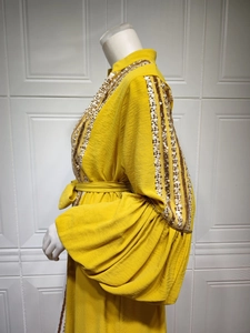 Detailed view of ginger yellow dress with sequin stripes and elegant lantern sleeves