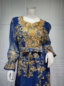 Detail of gold embroidery and sequins on navy long sleeve evening dress fabric