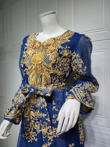 Detail of navy blue dress featuring intricate gold embroidery and sequin patterns