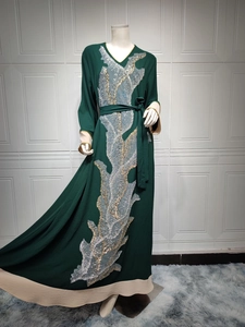 Détail de la broderie à paillettes argentées sur le caftan vert foncé à col en V doré