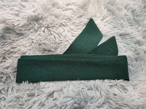 Texture détaillée d'une ceinture vert foncé en coton et lin avec couture fine sur peluche
