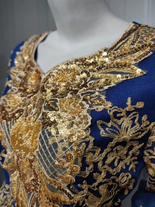 Detail of golden floral embroidery and sequins on navy blue ethnic evening gown neckline