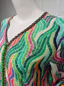 Detailed view of colorful wavy pattern dress with braided bead trim and V-neckline