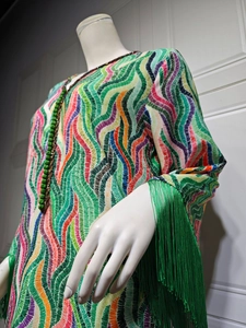 Detailed shot of ethnic printed dress with green silk tassels and beaded neckline