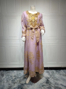 Detail of purple evening dress featuring gold floral embroidery and sequin neck embellishments