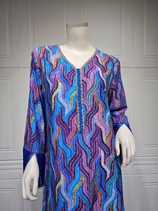 Close-up of V-neck with silver trim and blue tassels on a colorful printed dress