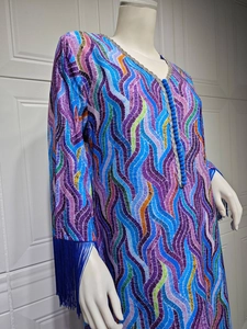 Detail of printed kaftan dress featuring V-neckline with blue braided trim and long tassels