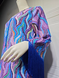 Detail of colorful wave pattern dress with deep blue long fringe tassels on sleeves