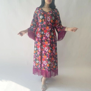 Ethnic purple kaftan dress with vibrant floral prints and purple tassel trim details
