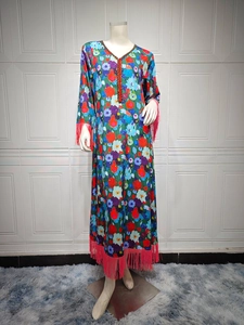 Detail of bohemian floral maxi dress featuring red fringe hem and V-neck tassel trim