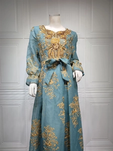 Detail of navy dress showing golden embroidery and sequins on textured fabric