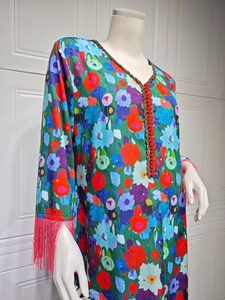 Detail of V-neckline with gold beads, red buttons, and floral patterns on ethnic dress