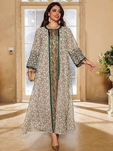 Detailed close-up of golden sequin embroidery and geometric patterns on a kaftan dress