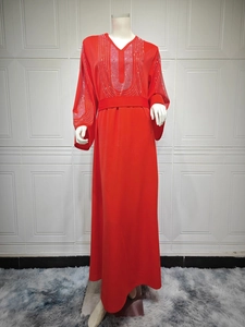 Détail de la robe de soirée rouge avec des strass argentés sur le buste et les manches
