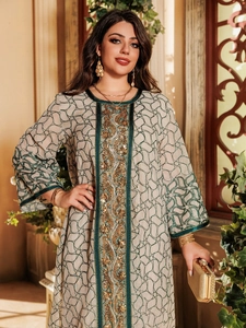 Close-up of ethnic mesh dress featuring green embroidery and gold sequin accents