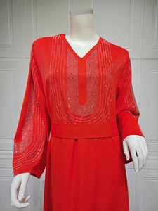 Vue détaillée des ornements en strass et du col en V sur la robe kaftan rouge