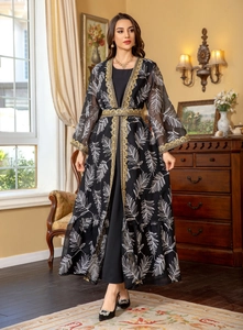 Close-up of golden lace embroidery and leaf patterns on a black ethnic mesh dress