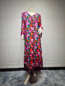 Detail of bohemian long dress showing colorful floral prints and purple tassel accents