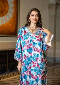 Detail of V-neckline with silver sequin trim on blue floral print long sleeve dress