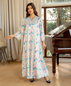 Détail d'une robe longue fleurie avec un col en V élégant et des paillettes argentées