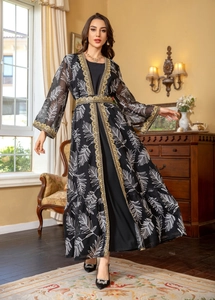 Close-up of golden lace embroidery on black mesh sleeves and front of the kaftan dress