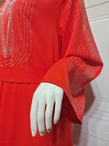 Gros plan détaillé d'une robe de soirée en mousseline rouge avec strass argentés brillants