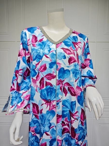 Detail of floral print kaftan with silver rhinestone trimming on the neckline and front