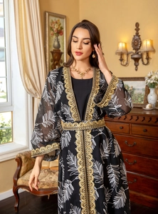Detail of black mesh abaya with gold embroidery, sequins and white leaf patterns