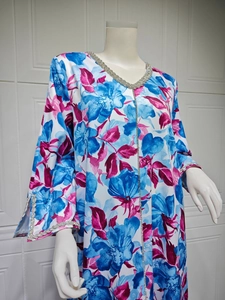 Detail of floral V-neck dress with blue pink patterns and shimmering rhinestone trim