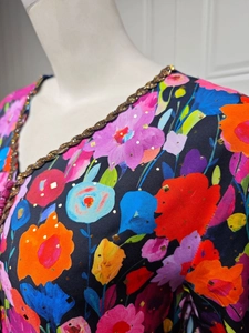 Detail of ethnic floral print with gold foil accents and sequined V-neckline trim