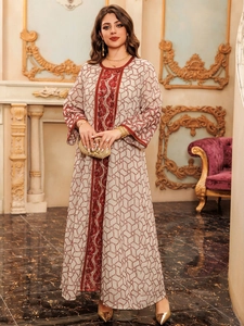 Detailed close-up of heavy floral beadwork and red embroidery on a mesh kaftan dress