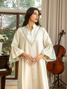 Detail of silver lace embroidery on V-neckline and bell sleeves of a satin maxi dress