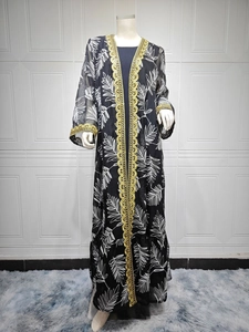Detail of ethnic mesh embroidery and gold ribbon trim on black printed abaya robe