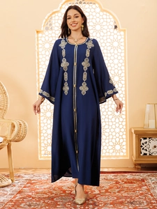 Détail de broderie géométrique dorée sur robe Abaya bleu marine à manches cloche