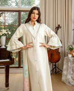 Exquisite floral embroidery detail on cream satin sleeve of an elegant long dress