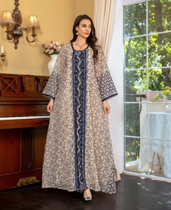 Detailed view of navy blue heavy embroidery and sequins on a beige mesh abaya dress
