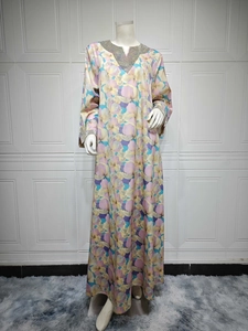 Détail d'une robe maxi fleurie avec décolleté en V à paillettes et imprimé coloré
