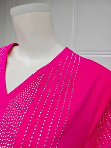 Détail d'une robe de soirée en mousseline rose avec des rangées de strass scintillants