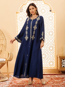 Détails de broderie géométrique dorée sur une robe kaftan bleu marine à manches longues