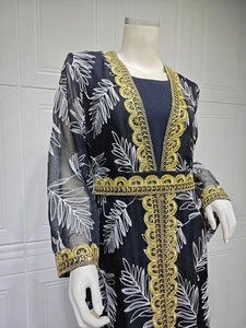 Detailed view of black ethnic abaya with gold embroidery sequins and leaf patterns