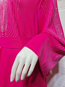 Détail de la robe de soirée en mousseline rose avec motifs ondulés en strass argentés