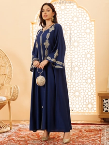 Détails d'une abaya bleu marine avec broderie géométrique dorée sur le buste et manches