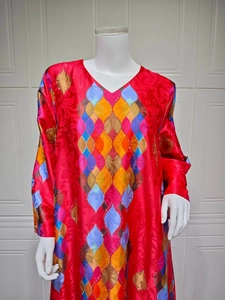 Detail of red V-neck maxi dress featuring geometric prints and sparkly rhinestone accents