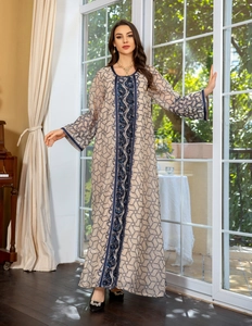 Close-up of blue sequin embroidery and wavy patterns on off-white chiffon dress