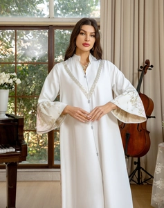 Detailed silver bead embroidery and floral patterns on white satin abaya sleeve